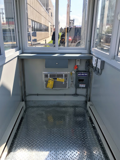 Interior of a prefabricated guard shack with a built-in AC unit, electrical and sliding windows.