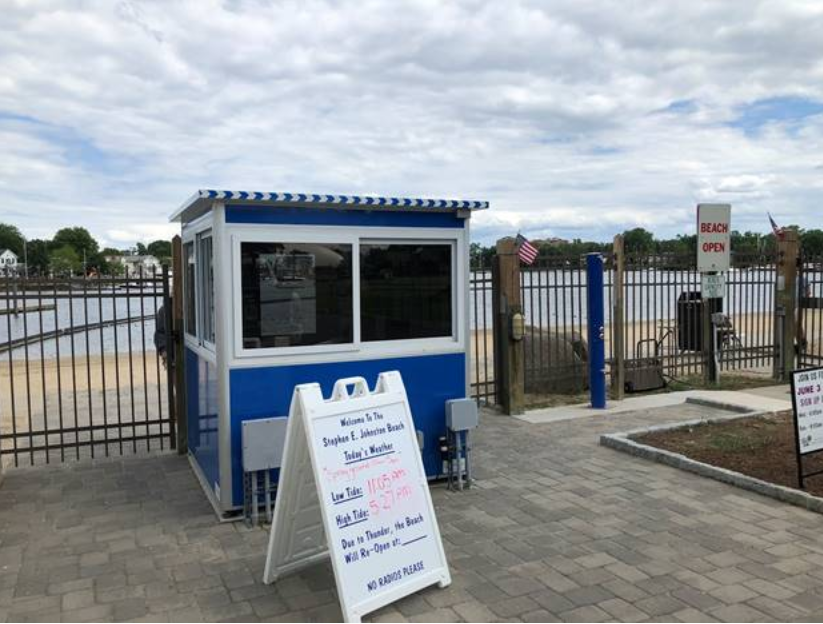 A blue ticket booth with an information sign out front. 