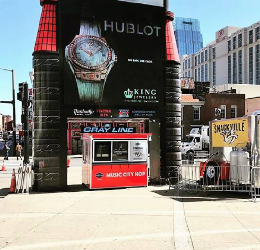 Red ticket booth with Music City Hop sign for Gray Line tours - Maximize Profits in Amusement Park Management Systems