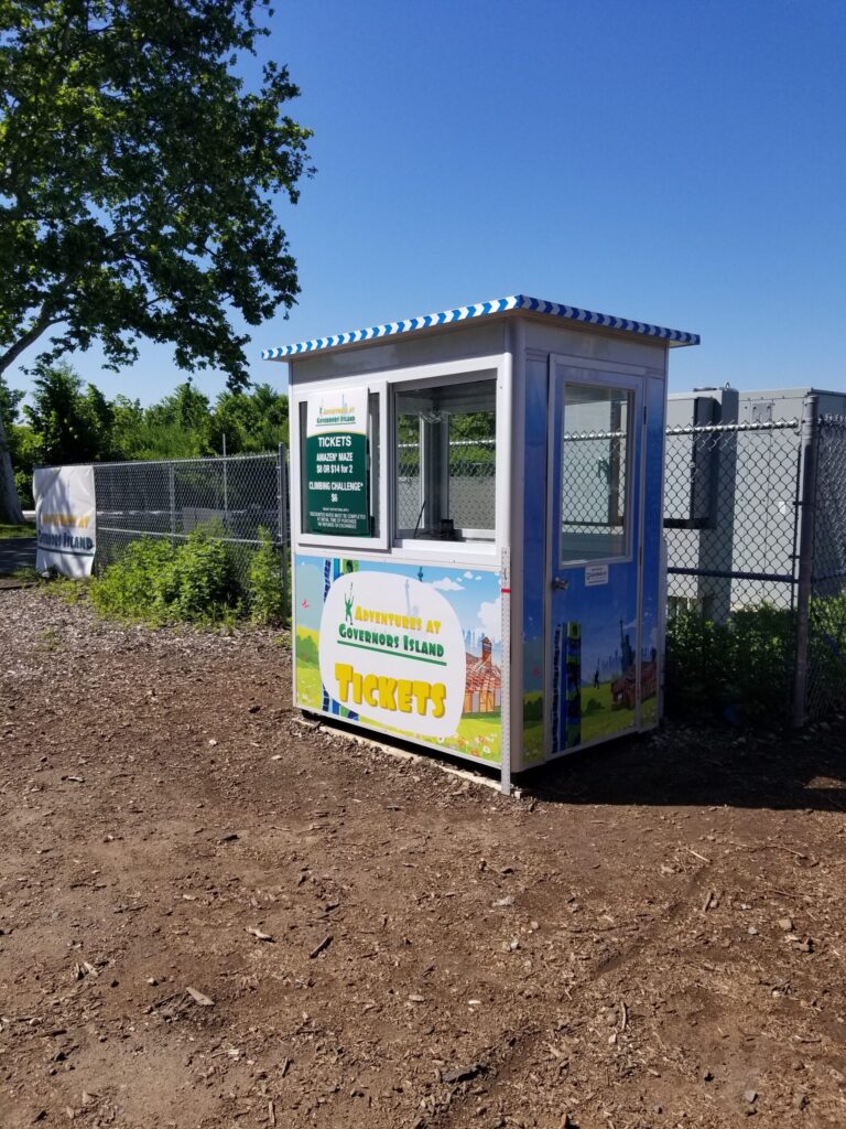4x6 Ticket Booth in Governor's Island, NY on Festival Grounds with Perimeter Security Fencing, Swing Door, and Sliding Windows