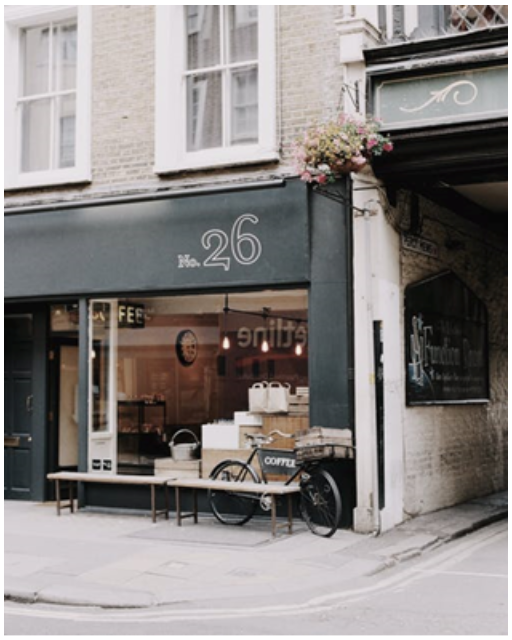 A storefront with a bike and benches out front