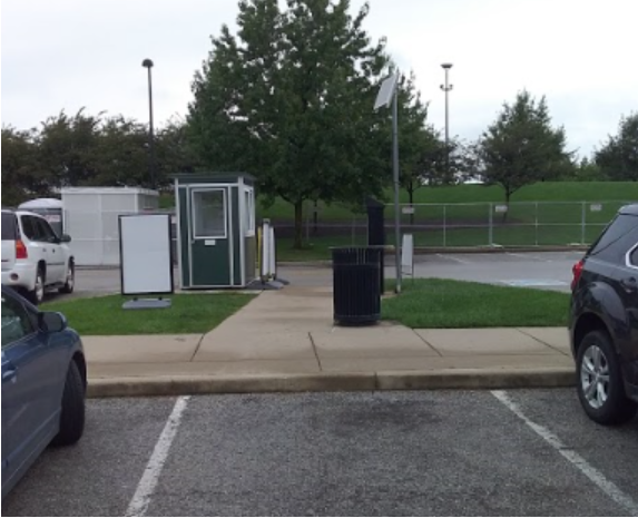 Parking lot with green parking booth in distance