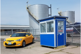 Yellow-car-parked-next-to-blue-security-booth