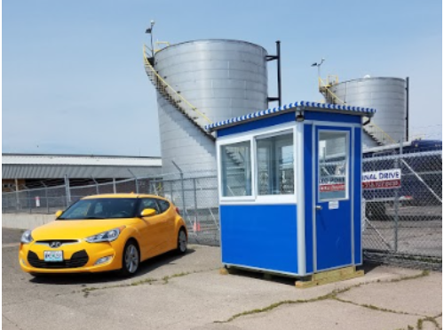 Yellow-car-parked-next-to-blue-security-booth