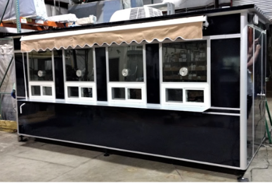 A black ticket booth with 4 windows and an awning