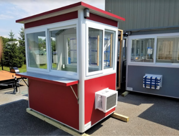 A red ticket booth with windows