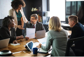 Professionally dressed people sitting around a conference table