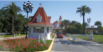 A large, white guard booth with palm trees around it