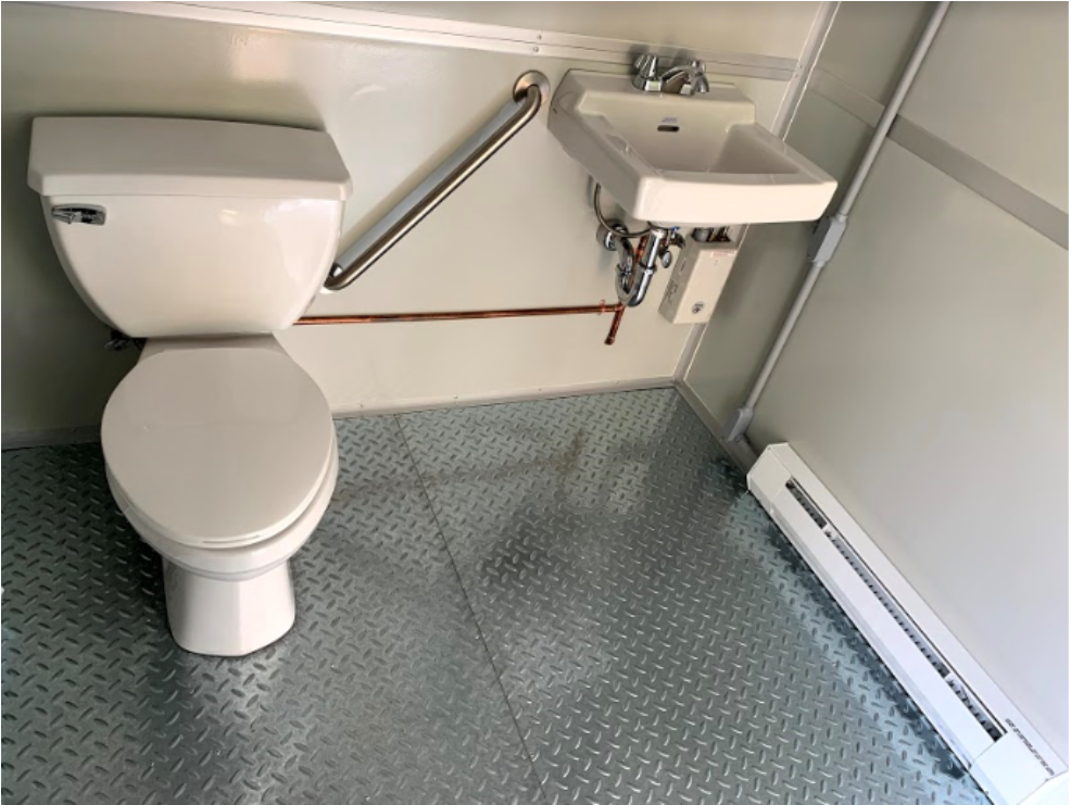 White, clean restroom with toilet, sink, metal floor