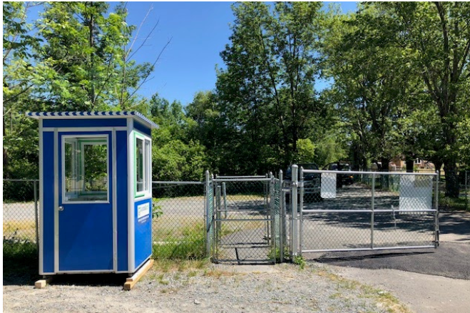 A blue guard booth outside a gate