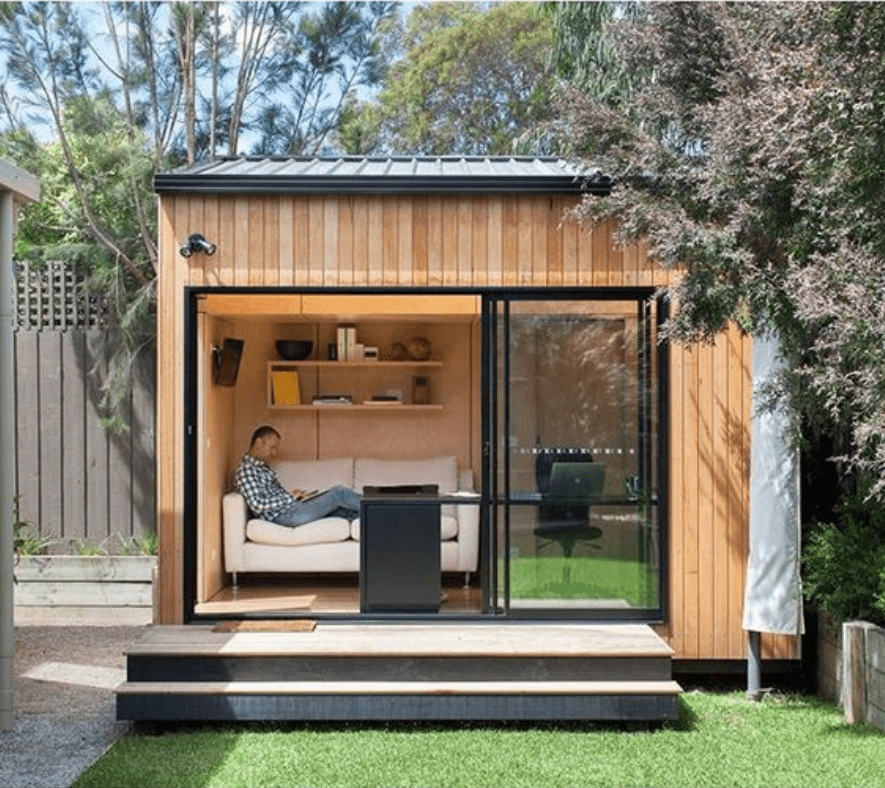 man working in backyard studio shed