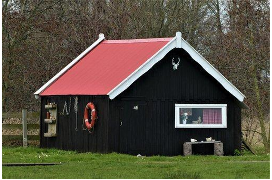 A large brown shed office with red roof