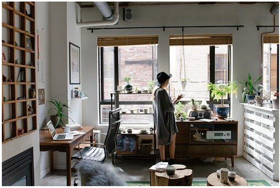 Office with windows, furniture, and a woman working