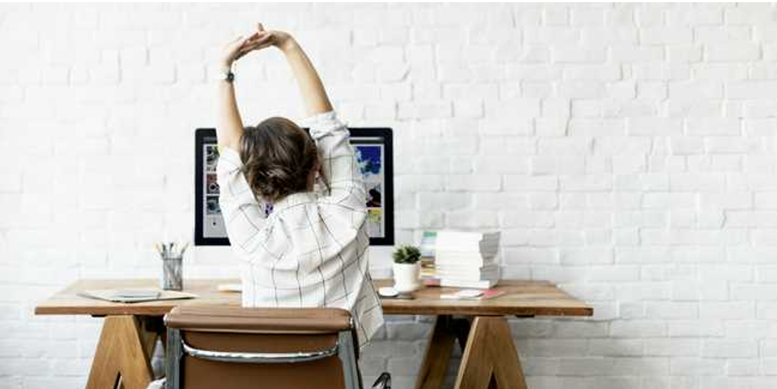 Women stretching at office desk