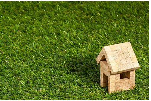 Wood toy cabin on green grass