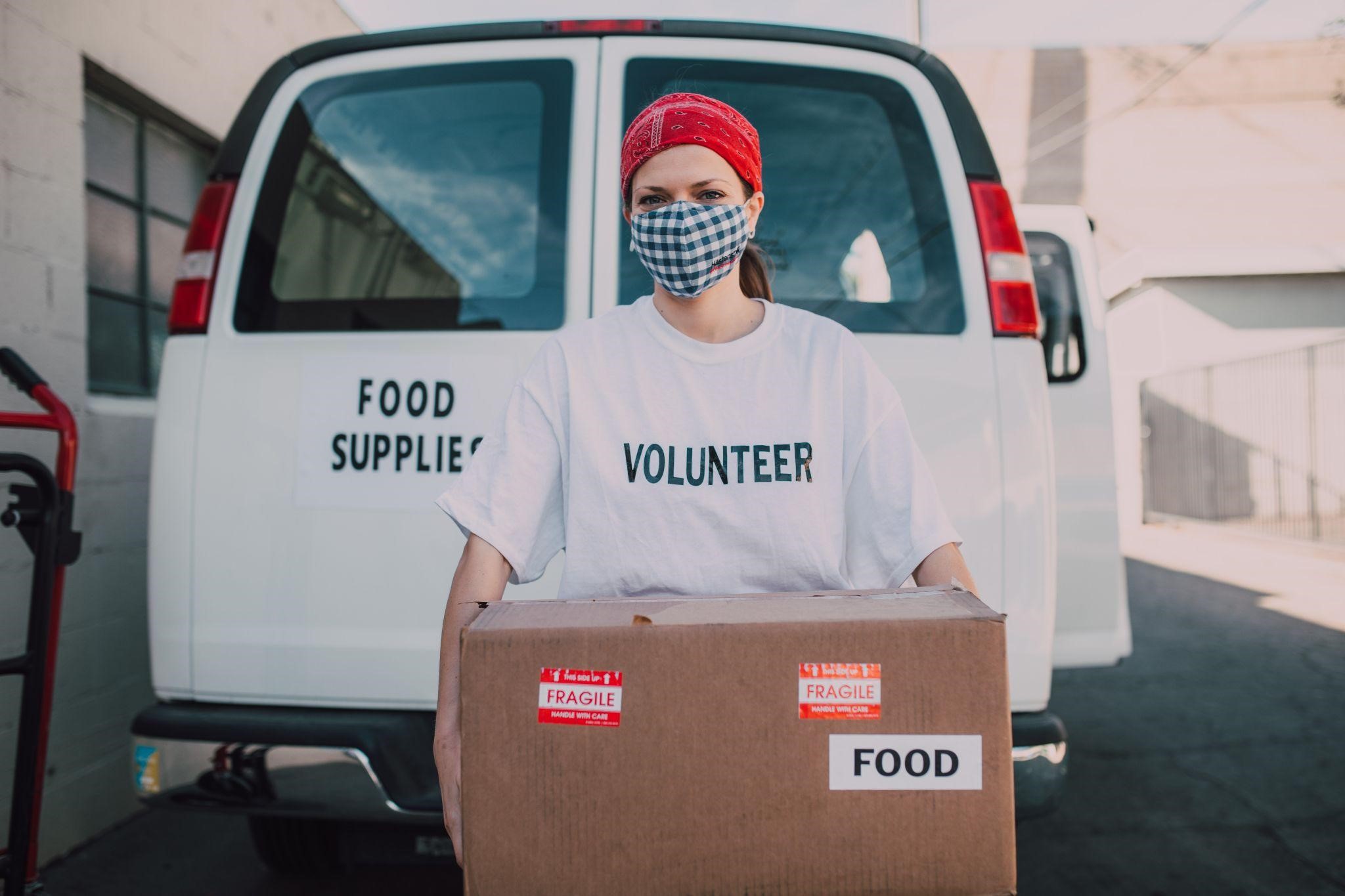 volunteer carrying box of food