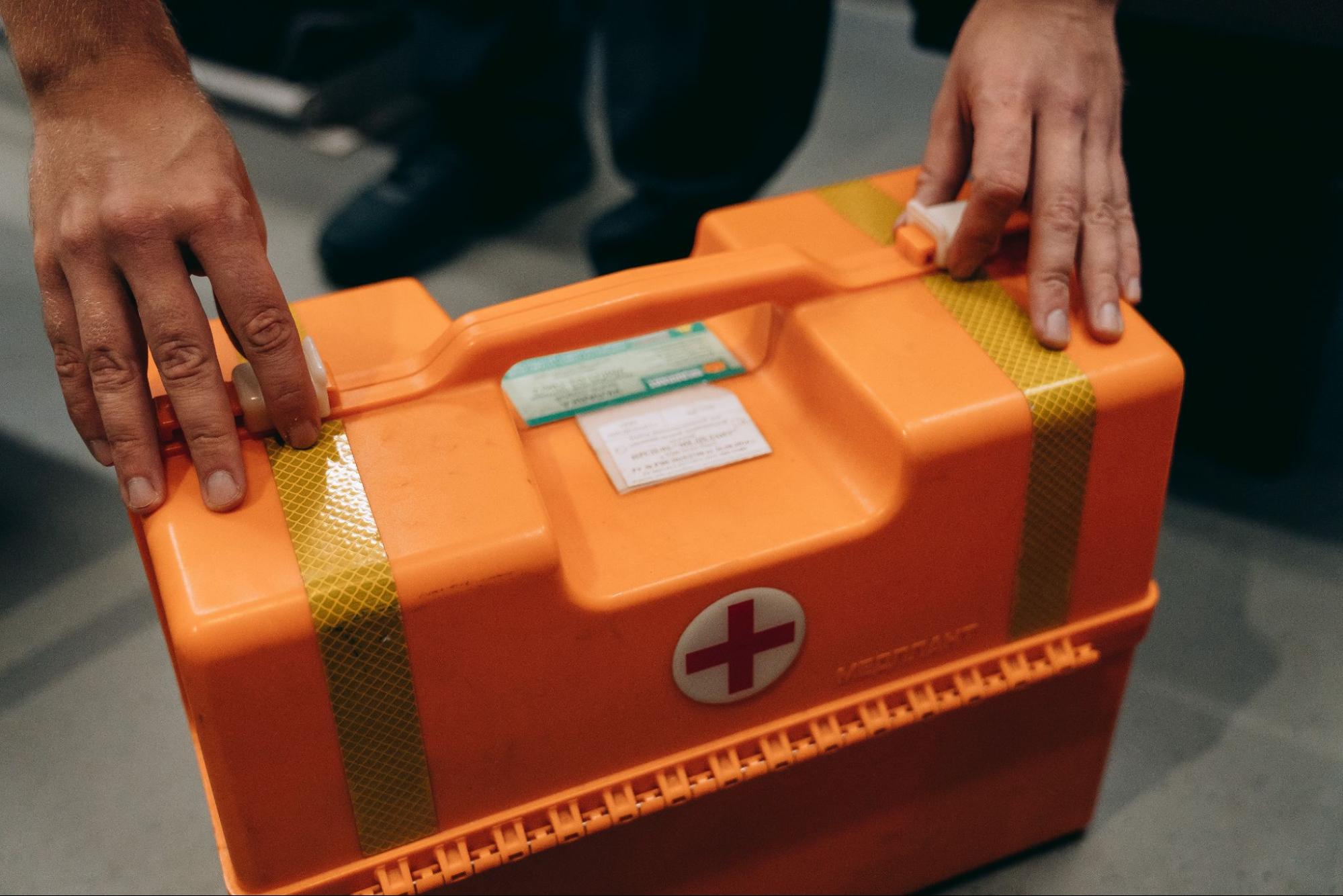 holding orange first aid kit