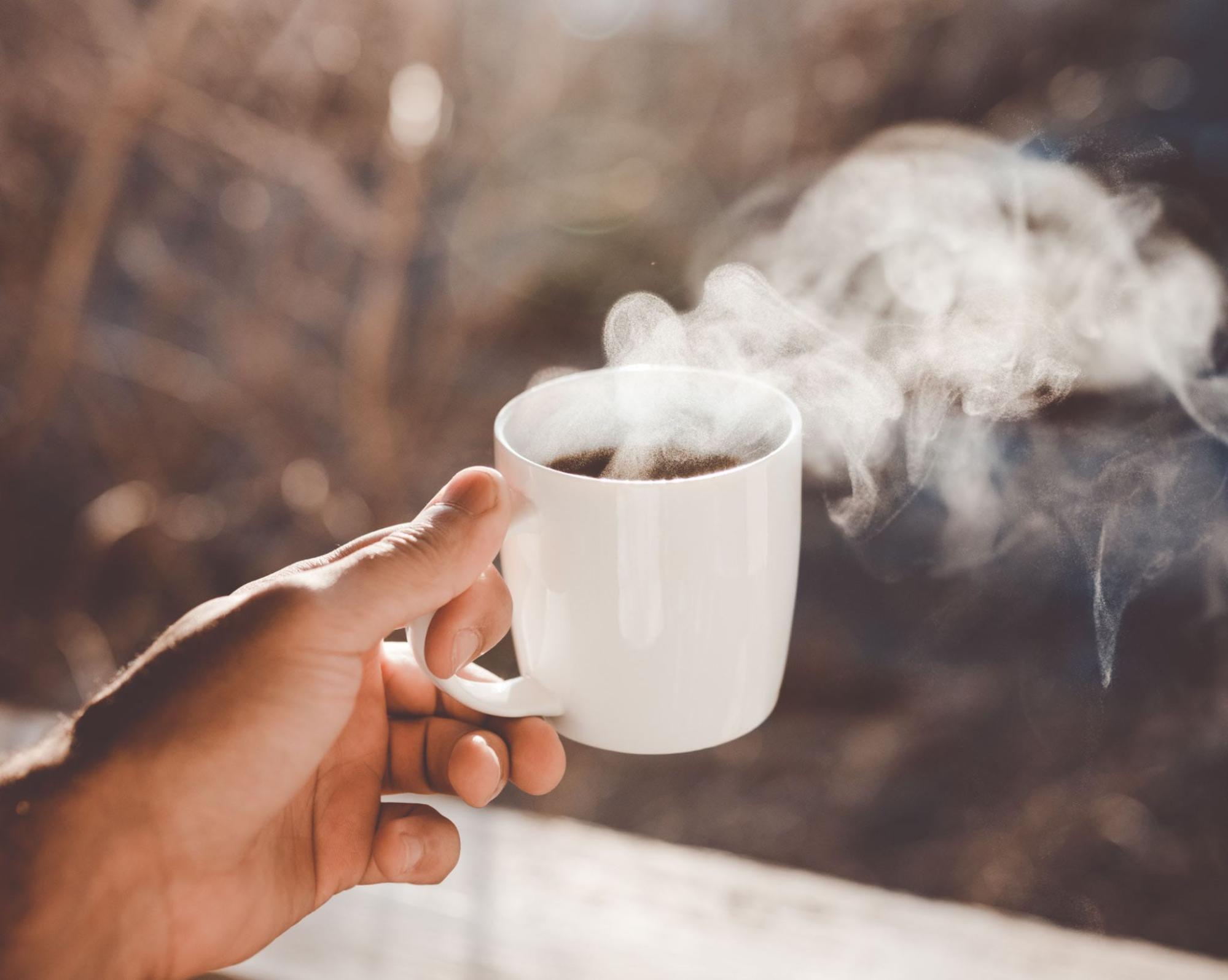 holding mug with steaming drink