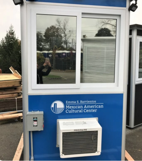 A blue tourism prefab booth displays the words Mexican American Cultural Center