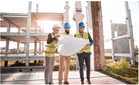 Construction workers in front of a building skeleton